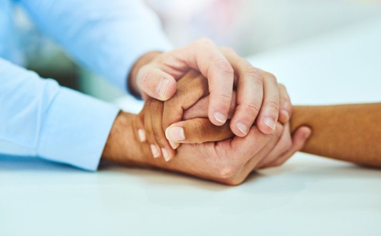 supportive hands comforting a grieving person